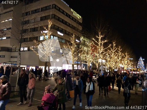 Image of People are walking through the city and the Christmas market