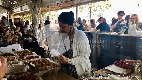 Image of People are enjoying delicious food at a Neighbourgoods Market at the waterfront of Cape Town, South Africa.