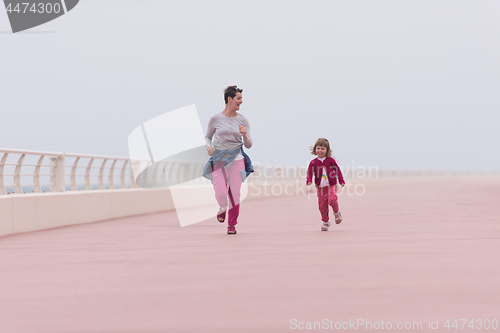 Image of mother and cute little girl on the promenade by the sea