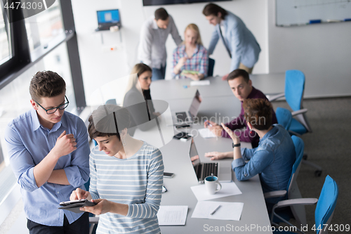 Image of Two Business People Working With Tablet in office