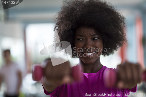 Image of woman working out in a crossfit gym with dumbbells