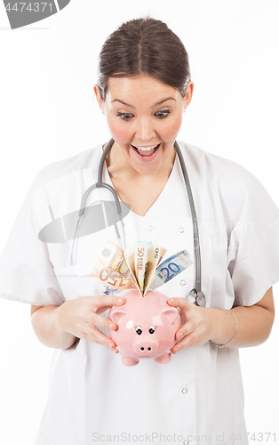 Image of happy woman doctor with piggy bank full of money