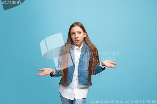 Image of Beautiful teen girl looking suprised and bewildered isolated on blue