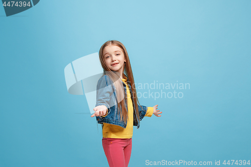 Image of Beautiful teen girl looking suprised and bewildered isolated on blue