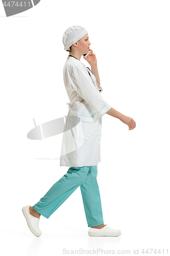 Image of Beautiful young woman in white coat posing at studio. Full length studio shot isolated on white.