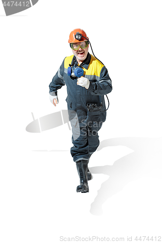 Image of The studio shot of senior bearded male miner standing at the camera on a white background.