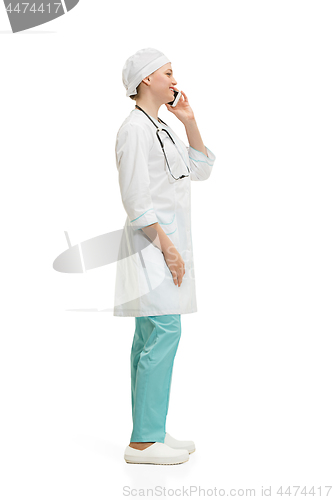 Image of Beautiful young woman in white coat posing at studio. Full length studio shot isolated on white.