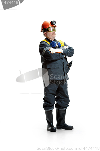 Image of The studio shot of senior bearded male miner standing at the camera on a white background.