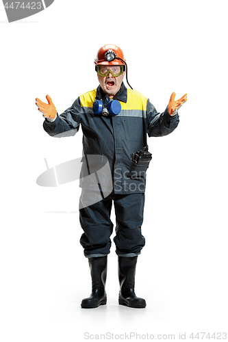 Image of The studio shot of senior bearded male miner standing at the camera on a white background.