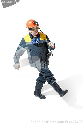 Image of The studio shot of senior bearded male miner standing at the camera on a white background.