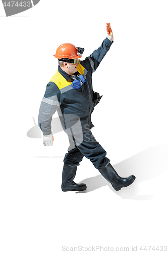 Image of The studio shot of senior bearded male miner standing at the camera on a white background.