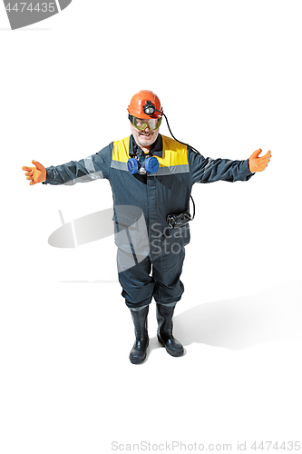 Image of The studio shot of senior bearded male miner standing at the camera on a white background.