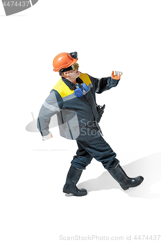 Image of The studio shot of senior bearded male miner standing at the camera on a white background.