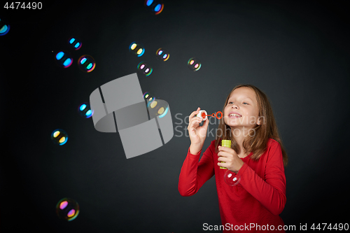 Image of Girl blowing soap bubbles