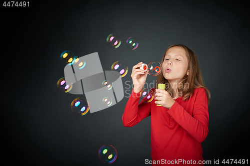 Image of Girl blowing soap bubbles