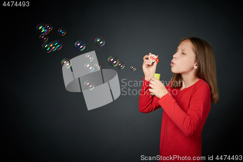 Image of Girl blowing soap bubbles