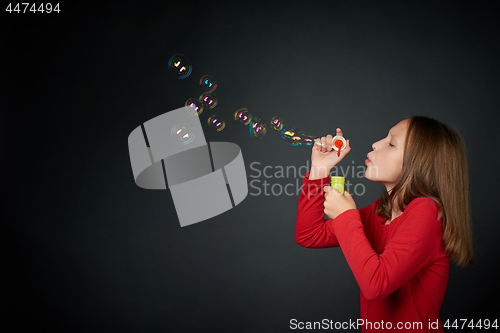 Image of Girl blowing soap bubbles