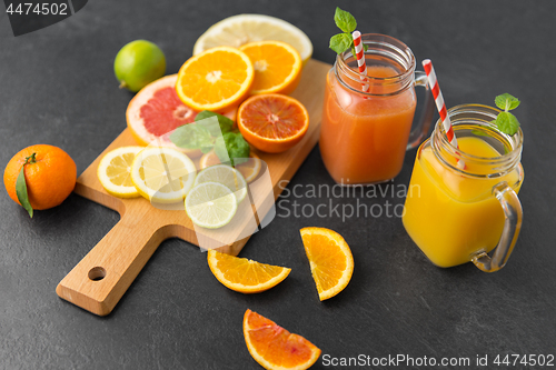 Image of mason jar glass with juice and fruits on table