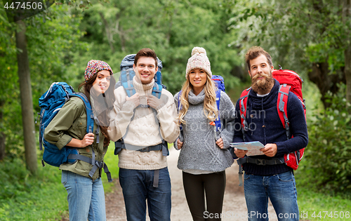 Image of friends or travelers hiking with backpacks and map