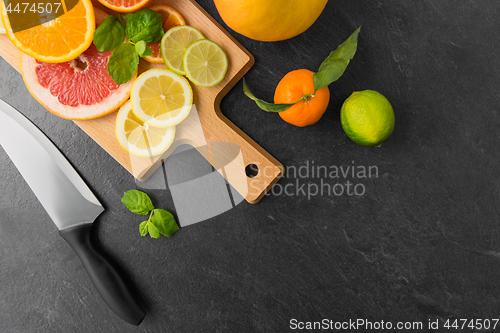 Image of close up of fruits and knife on slate table top