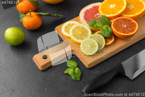 Image of close up of fruits and knife on slate table top