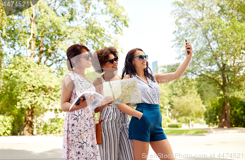 Image of women with city guide and map taking selfie