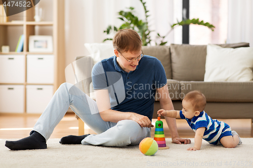Image of happy father with little baby son playing at home