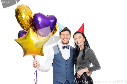 Image of happy couple with party caps and balloons