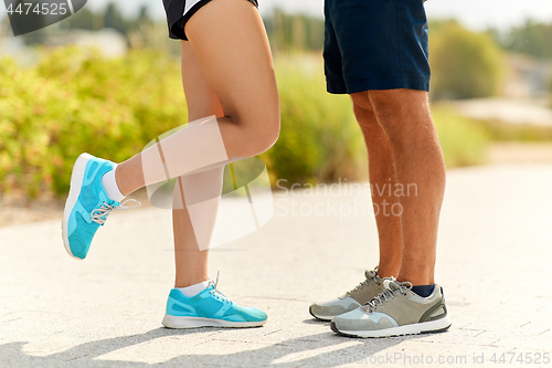 Image of legs of couple of sportsmen in sneakers outdoors