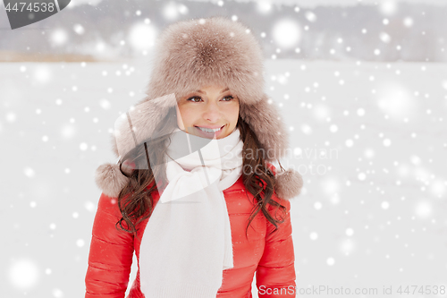 Image of happy woman in winter fur hat outdoors