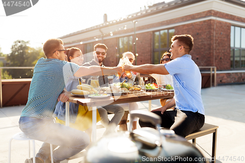 Image of friends toast drinks at barbecue party on rooftop