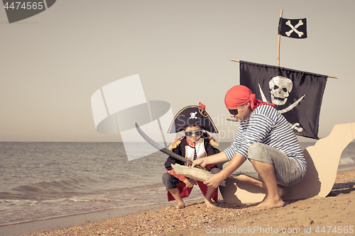 Image of Father and son playing on the beach at the day time.