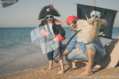 Image of Father and son playing on the beach at the day time.