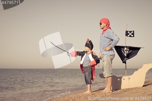 Image of Father and son playing on the beach at the day time.