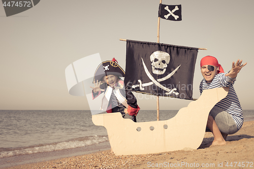 Image of Father and son playing on the beach at the day time.