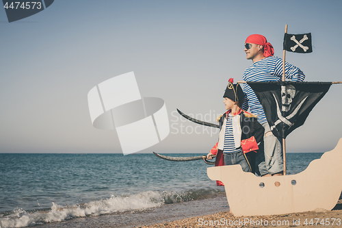 Image of Father and son playing on the beach at the day time.