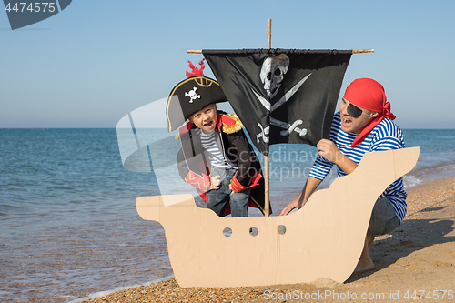 Image of Father and son playing on the beach at the day time.