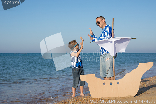 Image of Father and son playing on the beach at the day time.