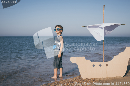 Image of One happy little boy playing on the beach at the day time.