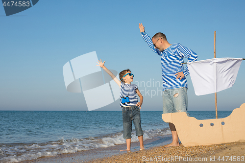 Image of Father and son playing on the beach at the day time.