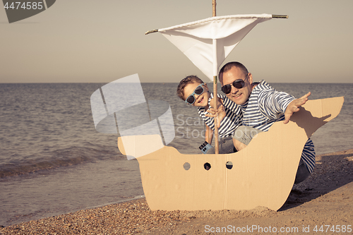 Image of Father and son playing on the beach at the day time.