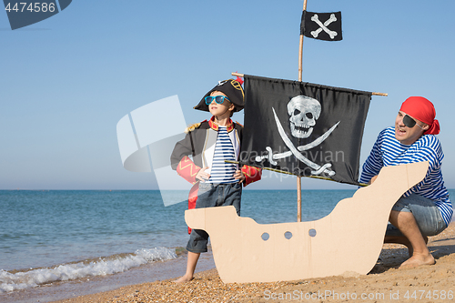 Image of Father and son playing on the beach at the day time.