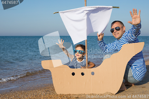 Image of Father and son playing on the beach at the day time.