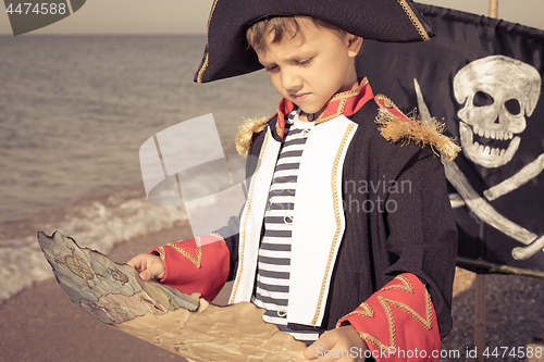 Image of One happy little boy playing on the beach at the day time.