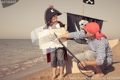 Image of Father and son playing on the beach at the day time.