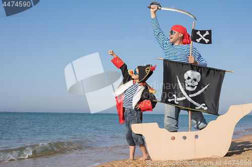 Image of Father and son playing on the beach at the day time.