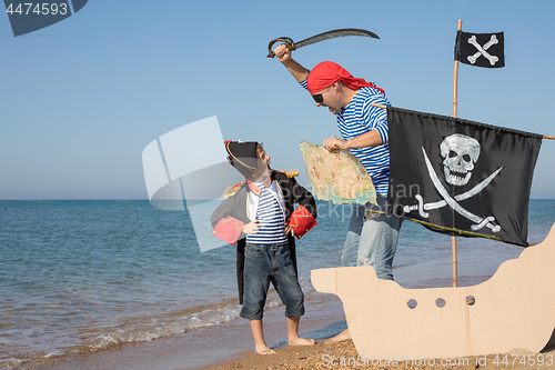 Image of Father and son playing on the beach at the day time.