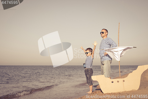 Image of Father and son playing on the beach at the day time.