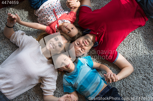 Image of happy family lying on the floor