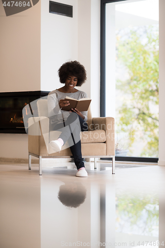 Image of black woman at home reading book